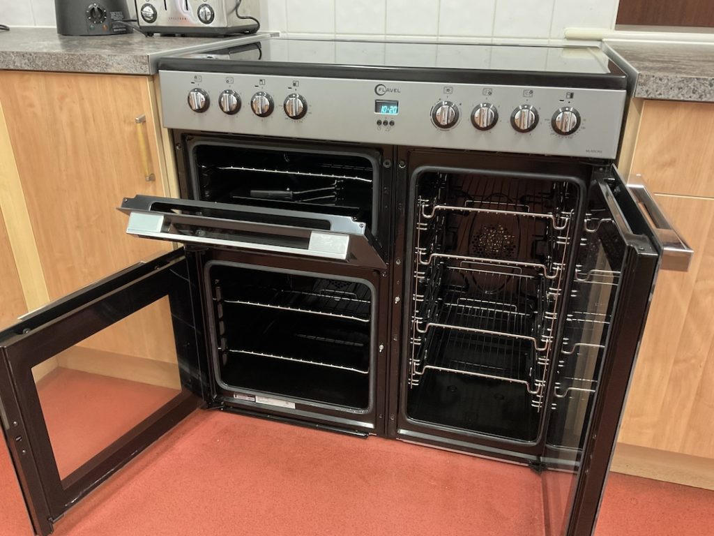 The new electric cooker installed in our kitchen with its doors open